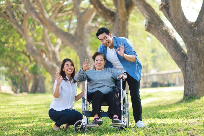 senior-asian-woman-wheelchair-family-outdoors