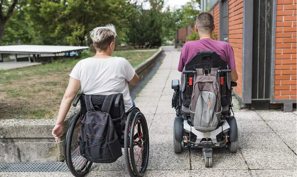 two-friends-with-disability-wheelchair-users-traveling-down-the-city-street