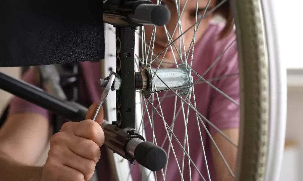 young-man-repairing-wheelchair-at-home-closeup