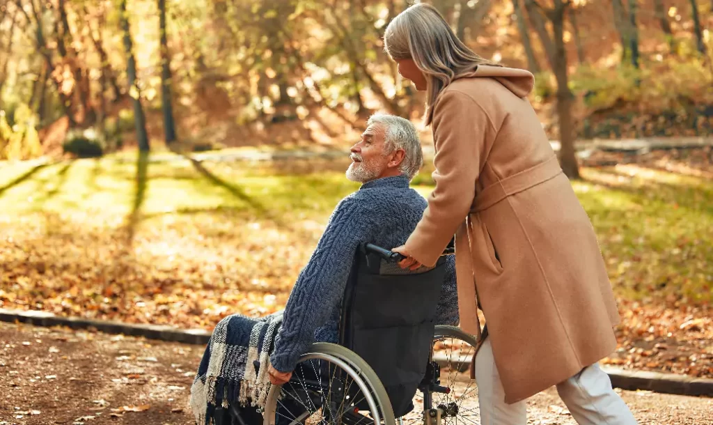 the-caregiver-joyfully-pushes-the-seniors-wheelchair-through-the-forest