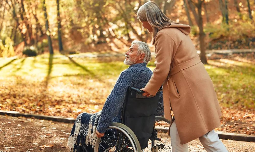the-caregiver-joyfully-pushes-the-seniors-wheelchair-through-the-forest